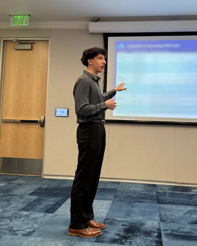 Chase Patterson presenting during an Avalyn Pharma presentation in front of a projected slide.